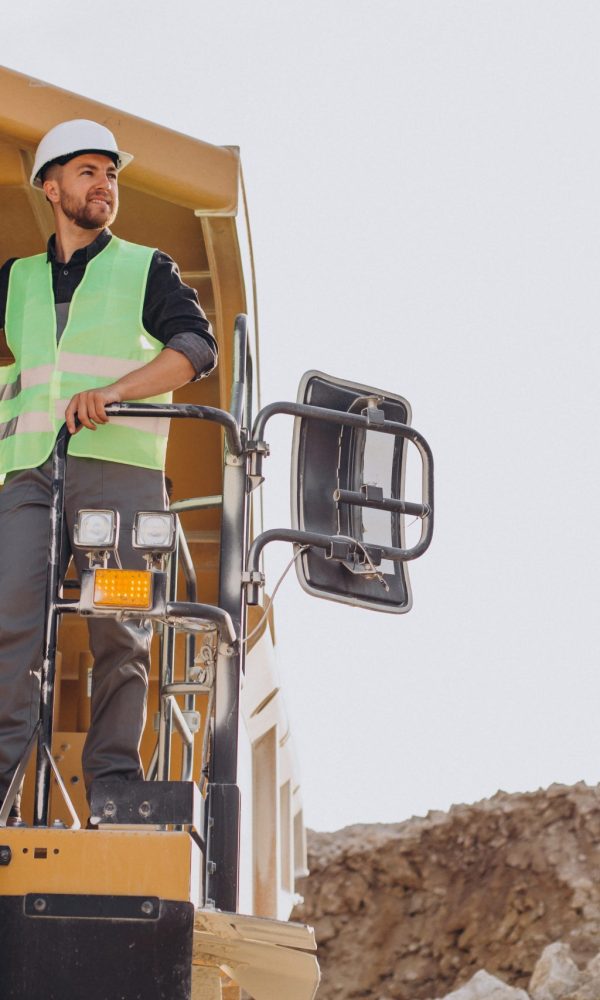 Male worker with bulldozer in sand quarry